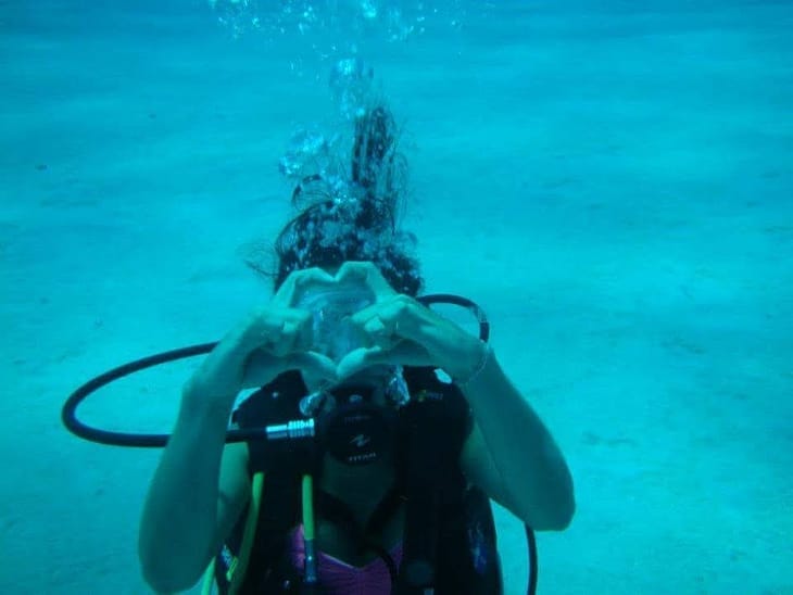 Caro underwater, hands making the shape of a heart